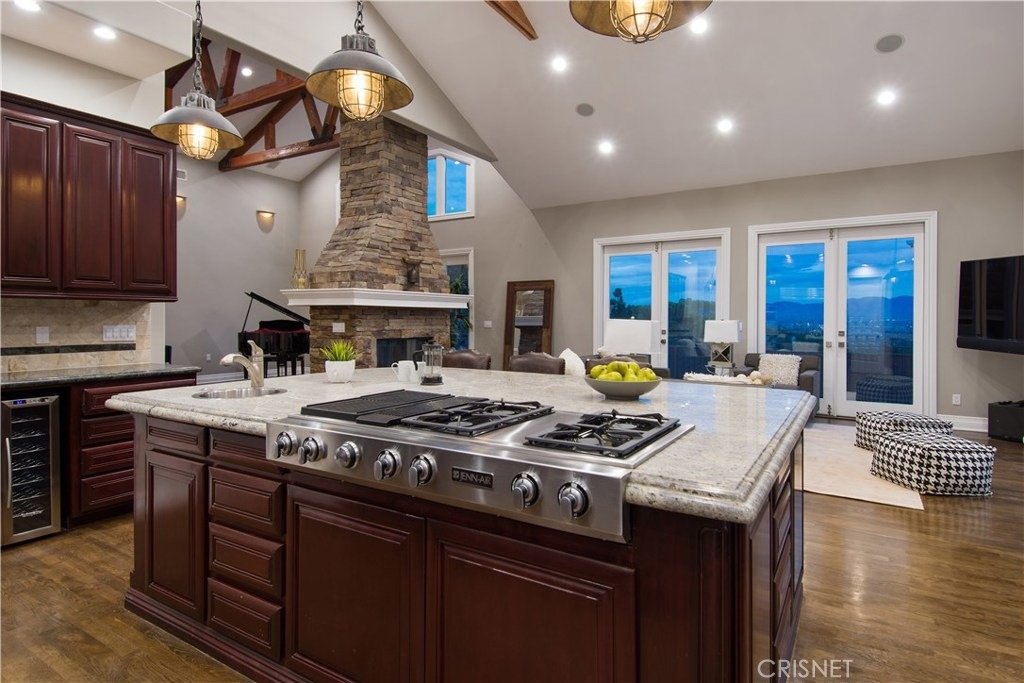 Kitchen with large island, dark cabinets, and granite countertops.