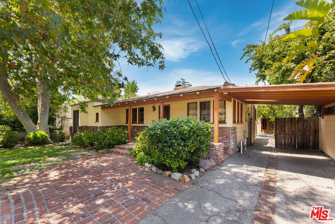 California real estate house with brick path, trees, shrubs, carport, and driveway