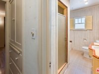 Hallway leading to bathroom with shower and toilet