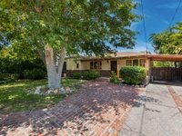 California real estate house with porch, tree, green plants, and driveway