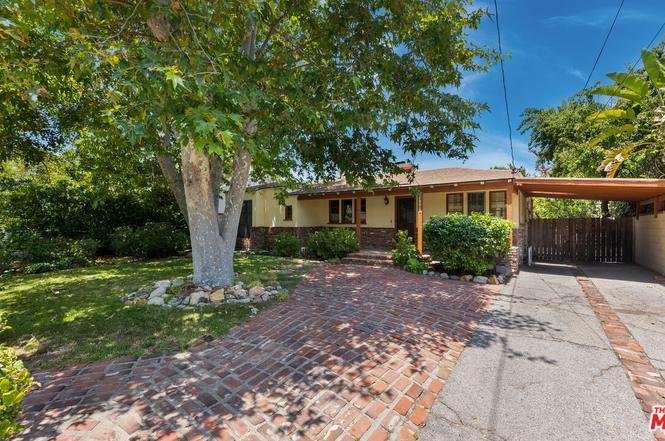California real estate house with brick path, trees, and green plants