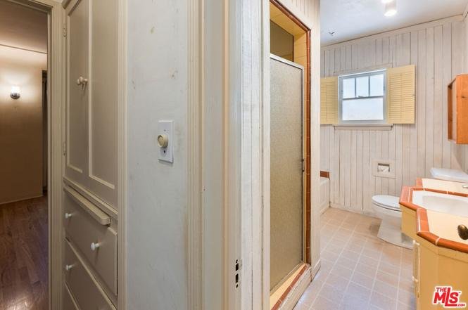 Hallway leading to bathroom with shower and sink