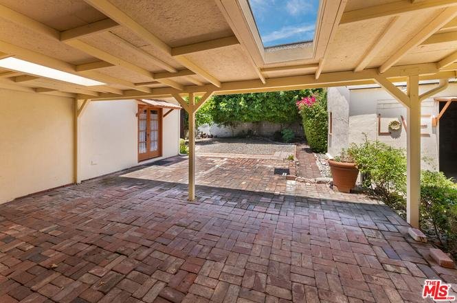 Patio with brick floor, green plants, potted plants