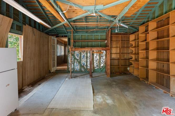 Empty room with wood walls, shelves, and open space