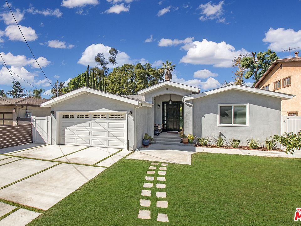 California real estate home with lawn, stone path, and garage.