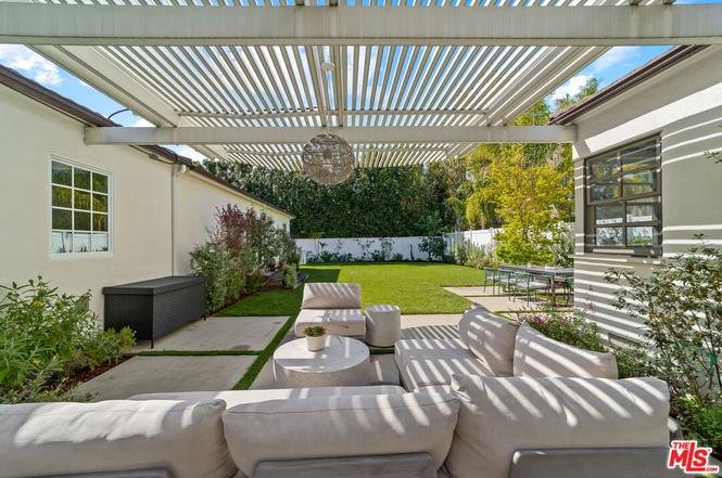 Luxury California real estate house backyard with patio seating, pergola, lawn, and garden.