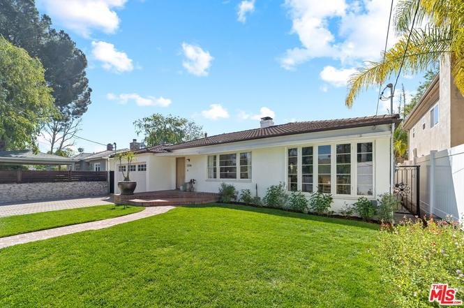 California real estate house with green lawn, front pathway, windows, and trees.
