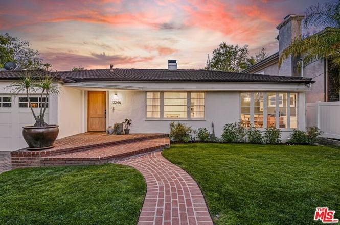 Luxury California real estate house with front yard and brick pathway.