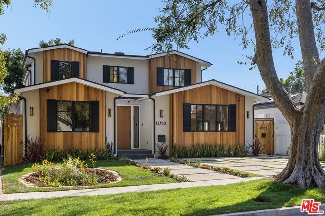 California real estate two-story home with wood and white exterior, large windows, and landscaped front yard