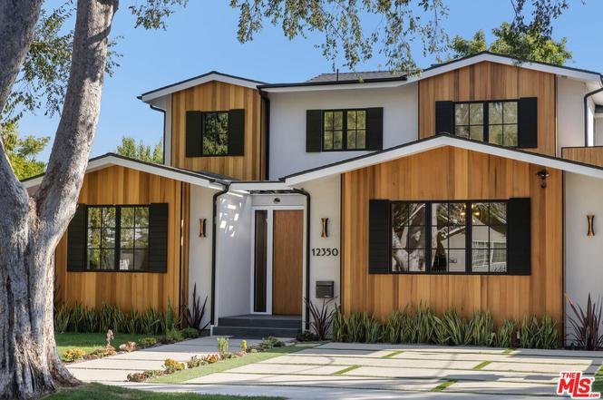 California real estate two-story home with wood and white siding, large windows, and manicured lawn