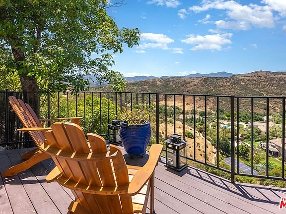 Deck with two wood chairs and wide hill and mountain view California real estate.