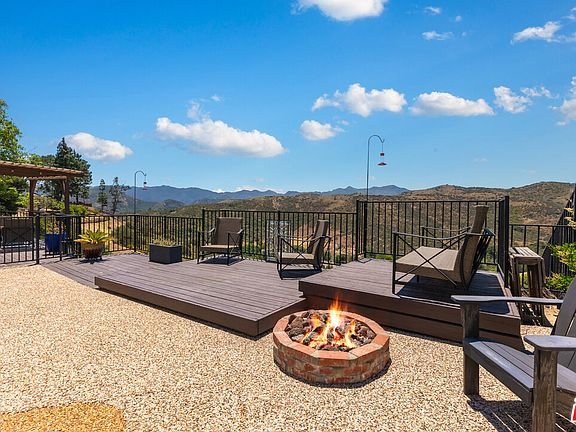 Backyard patio with fire pit, seating area, and mountain view California real estate.