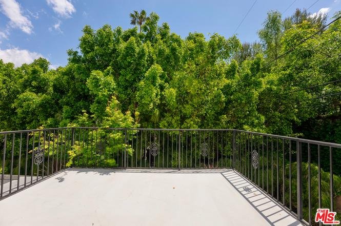 Balcony view of garden with trees and green plants.