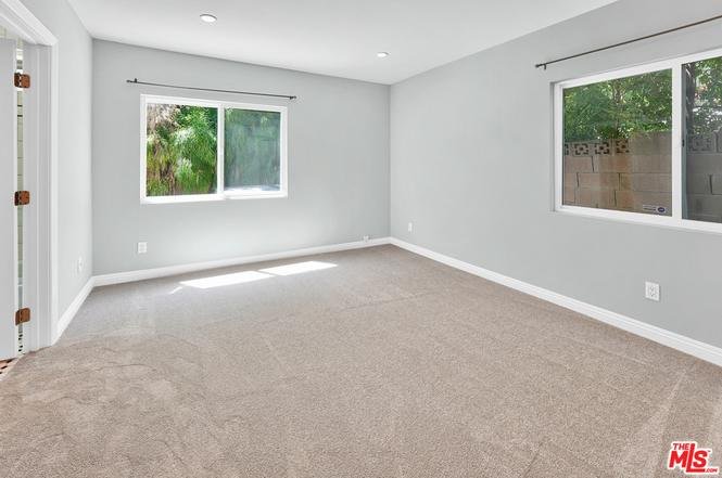 Room with gray walls, large windows, and carpet floor.