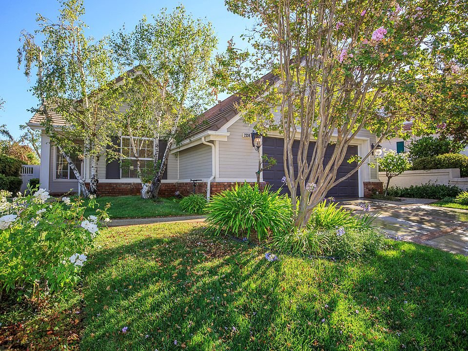 California real estate home with light exterior, garage, and green front yard