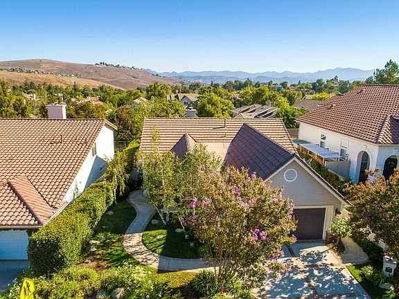 House address plaque 2334 on stone wall with surrounding greenery