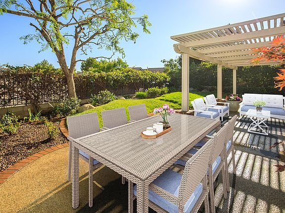 California real estate house patio with table, chairs, pergola, and plants.