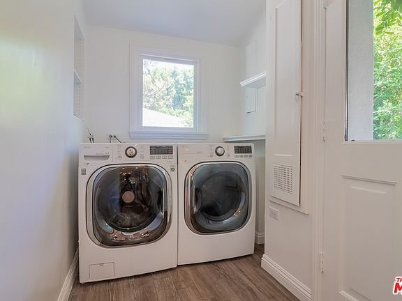 Laundry room with washer, dryer, window, and light walls.