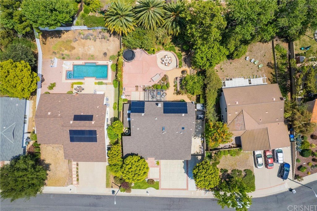 Aerial view of California real estate houses with solar panels, pool, and yards.