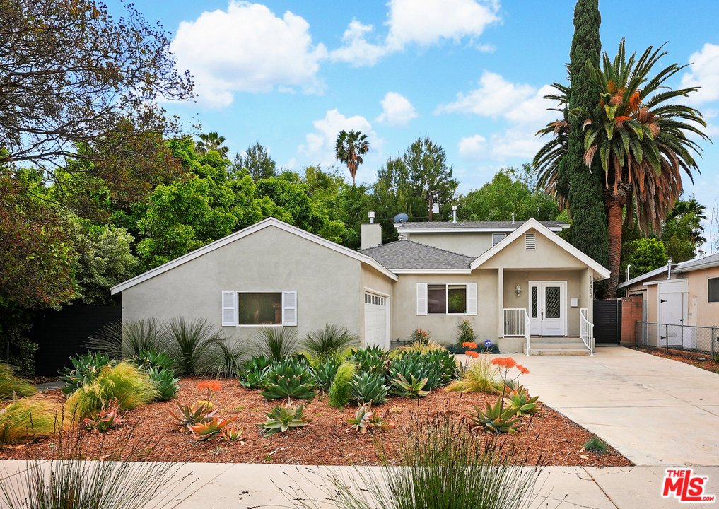 California real estate house with driveway, plants, and trees.