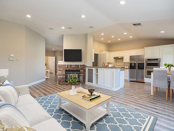 Kitchen with granite countertops, white cabinets, and light wood floor