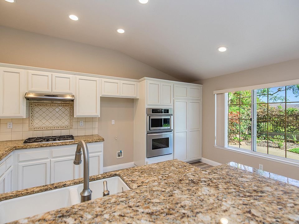 Kitchen with light cabinets, granite countertops, and stainless steel appliances