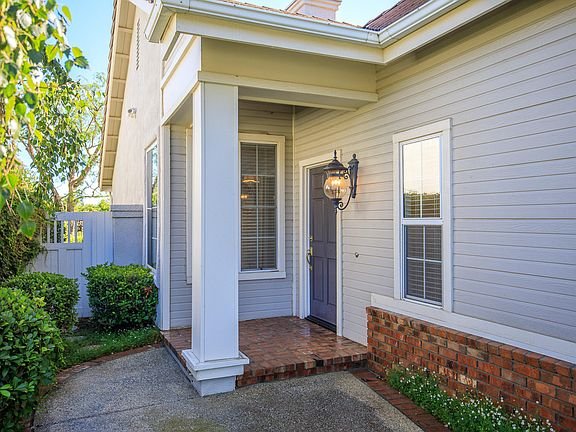 Front door with dark purple color, gray siding, lantern light, and window with blinds