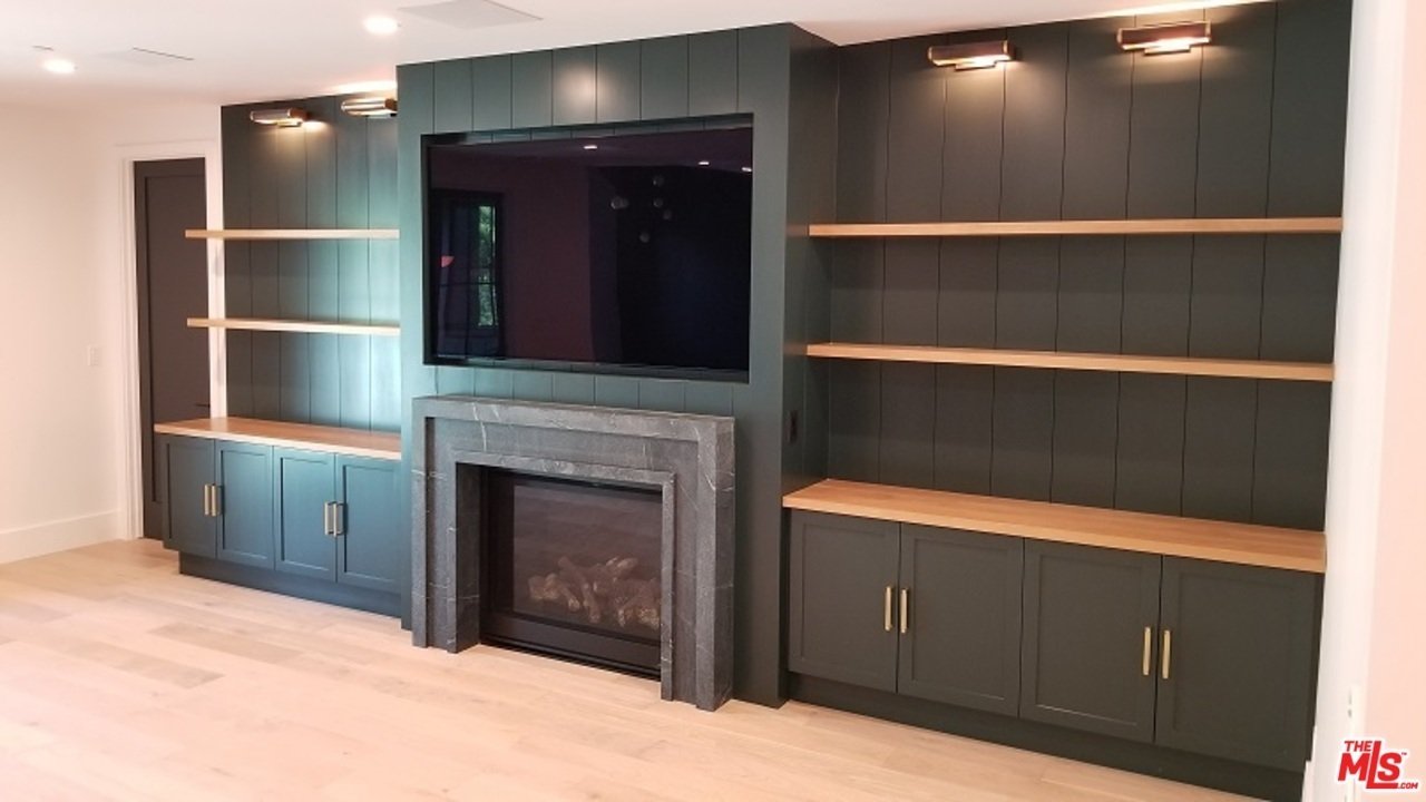 Living room with built-in shelves, fireplace, and dark cabinets.
