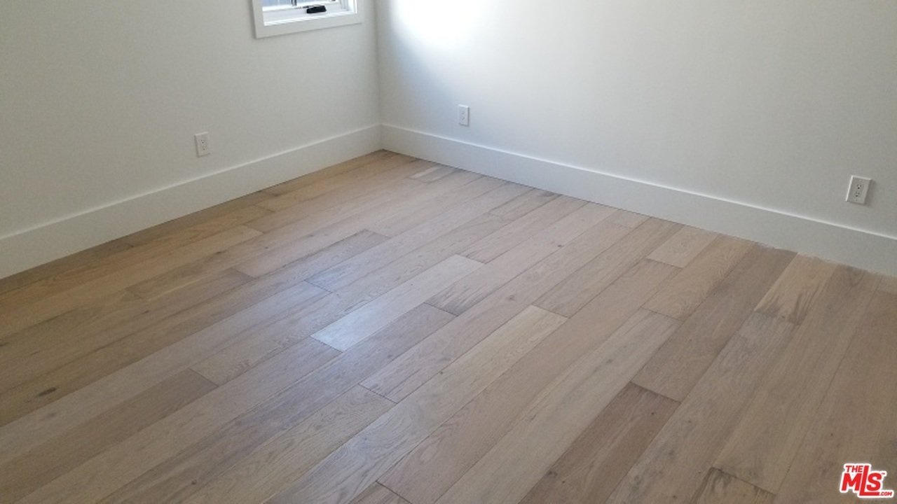 Empty room with wooden floor and white walls.