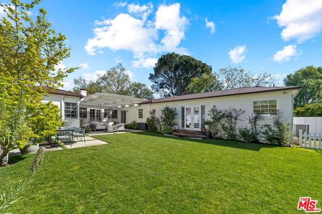 California real estate house backyard with green lawn, patio seating, and garden.