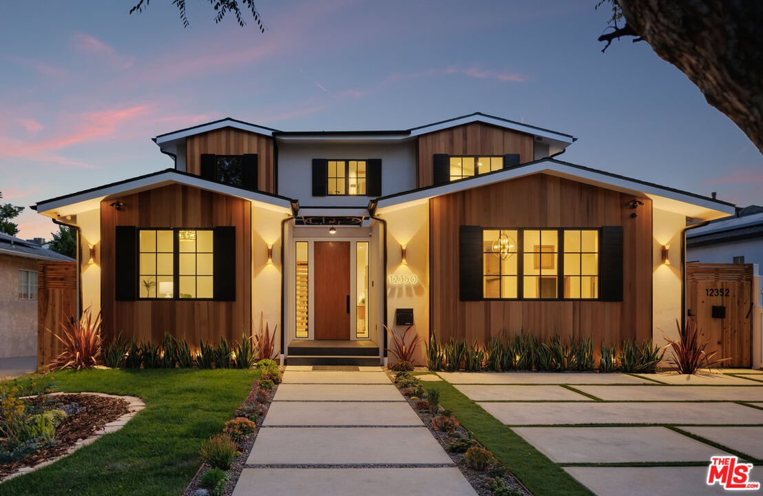 California real estate two-story home with wood and white exterior, large windows, and landscaped front yard