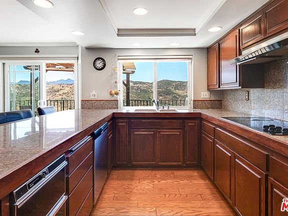 Kitchen with wood cabinets, granite counter, and window with mountain view.