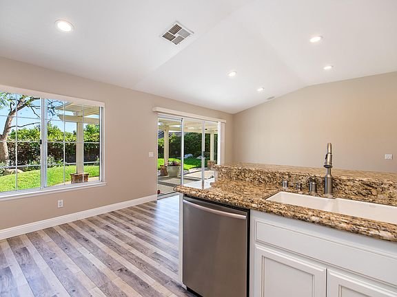 Kitchen with granite countertop, stainless steel sink, and wooden floor