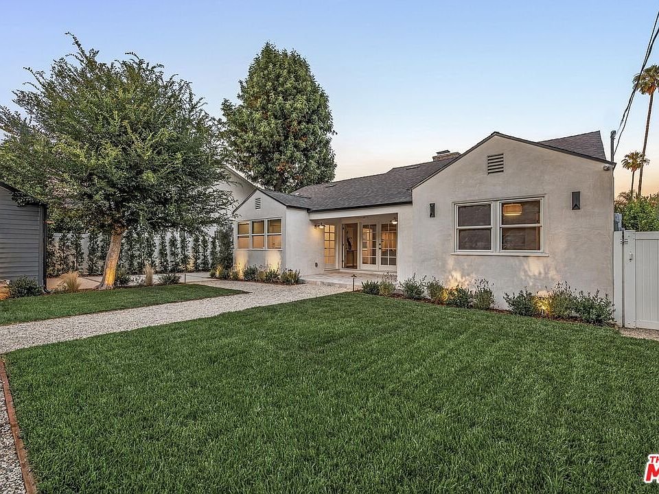 California real estate home with white exterior, gravel pathway, and landscaped yard