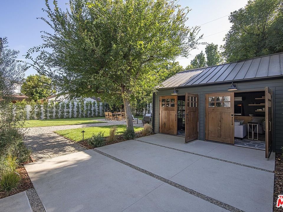California real estate home with modern garage, wooden doors, and landscaped yard
