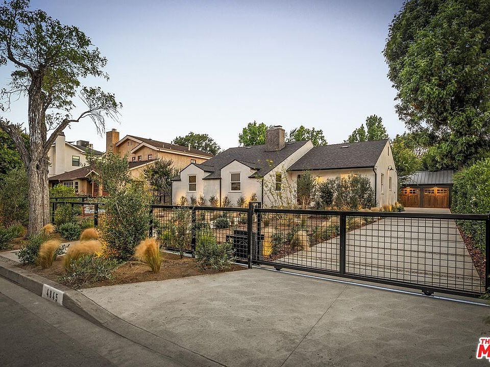 California real estate home with gray exterior, two-car garage, and green yard